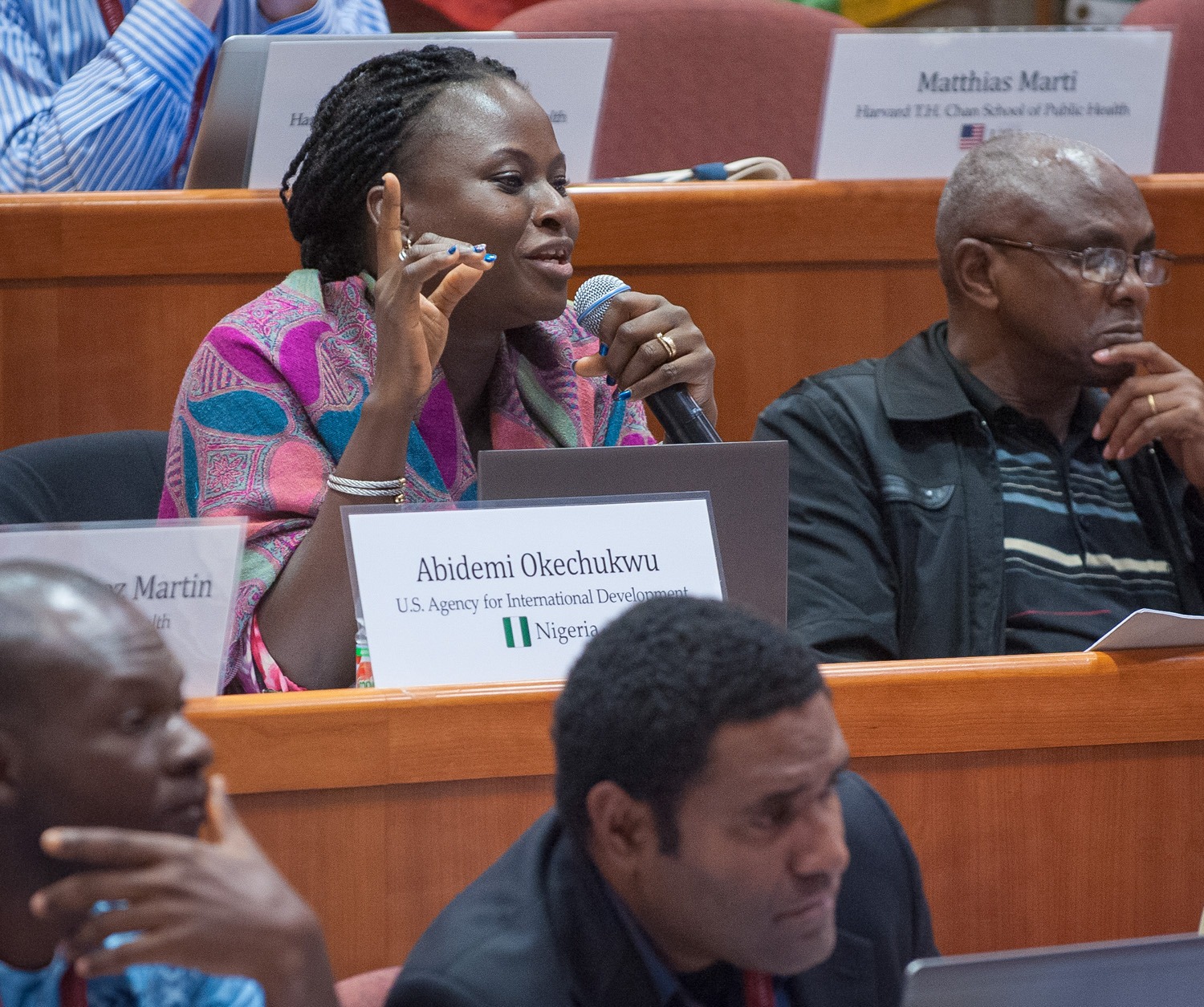 Abidemi Okechukwu ispeaks actively while seated among a group during a discussion at "Science of Eradication: Malaria" in Boston, MA, USA in 2018.